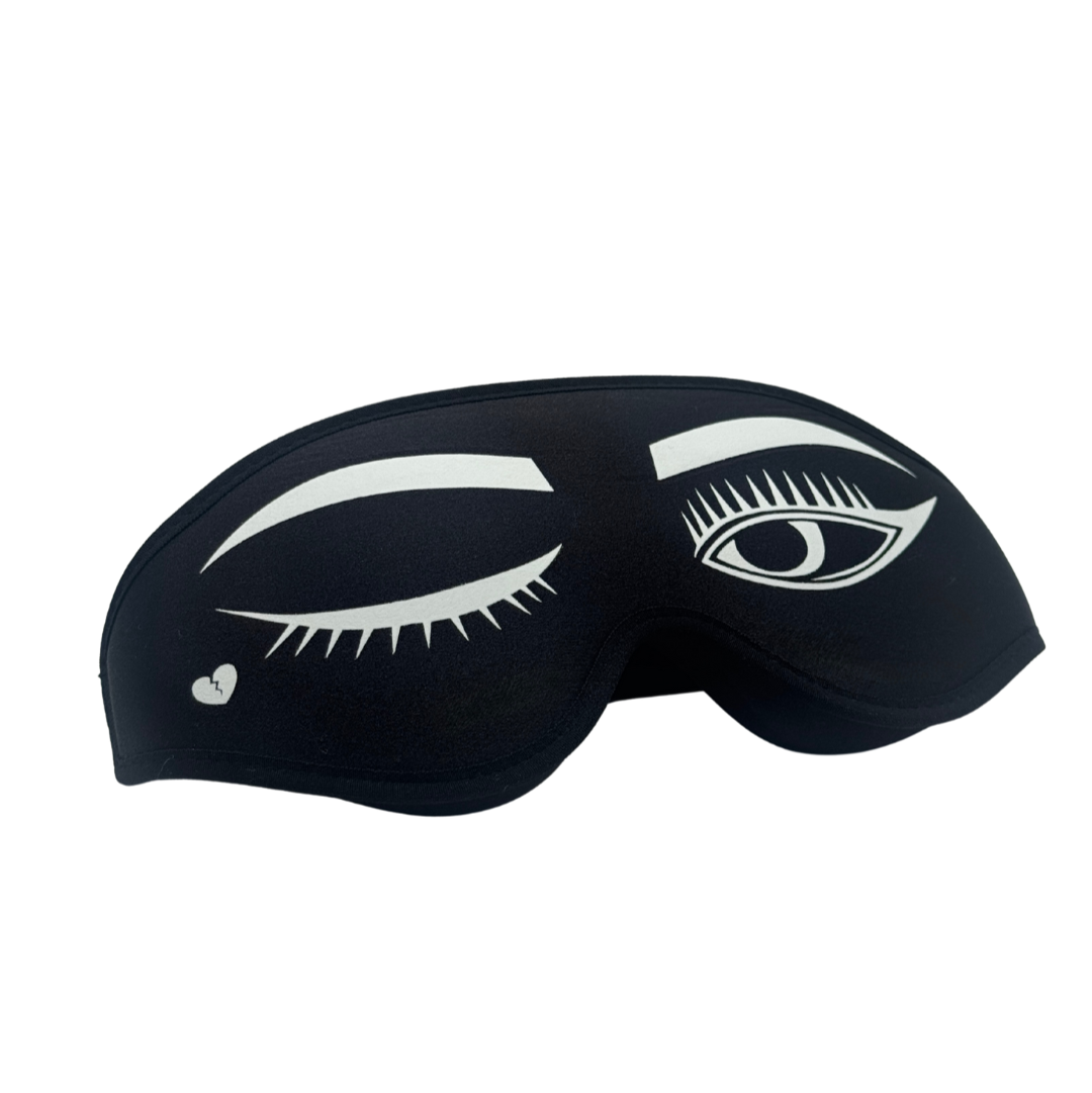 Black sleep mask with white eye design on a white background