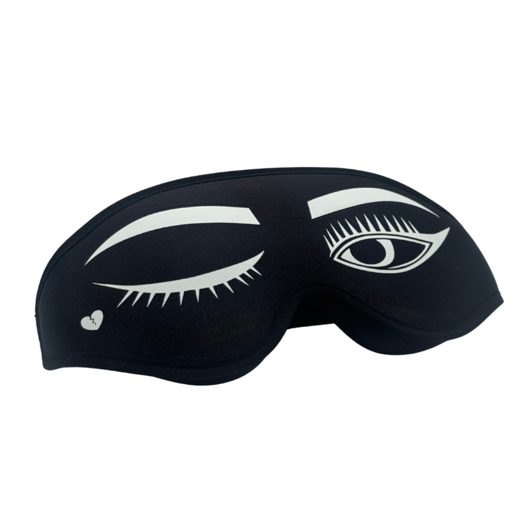 Black sleep mask with white eye design on a white background